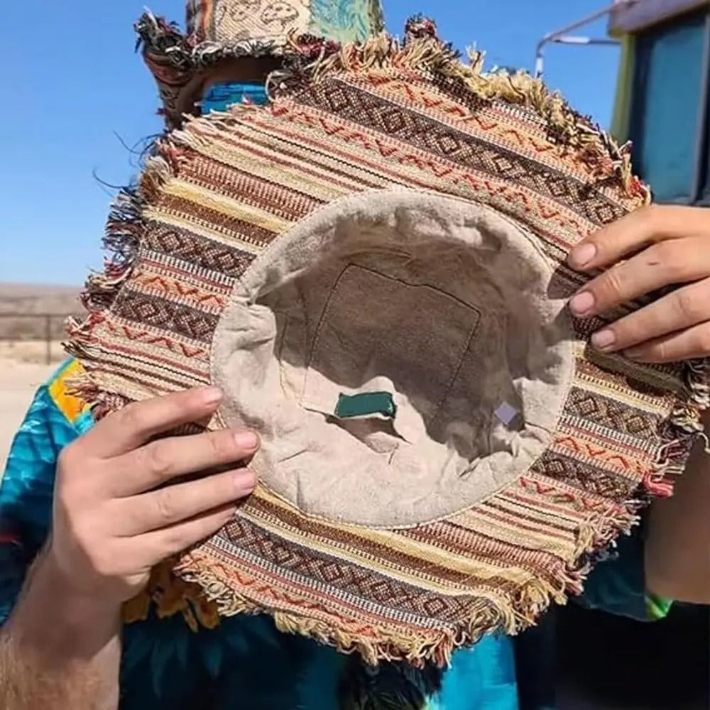 Decorative pillow with intricate patterns held by a person outdoors.